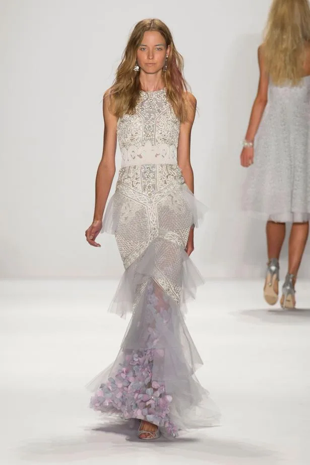 Model walks runway in an elegant floral-embellished gown with layered tulle skirt at Badgley Mischka Spring/Summer 2015 show.