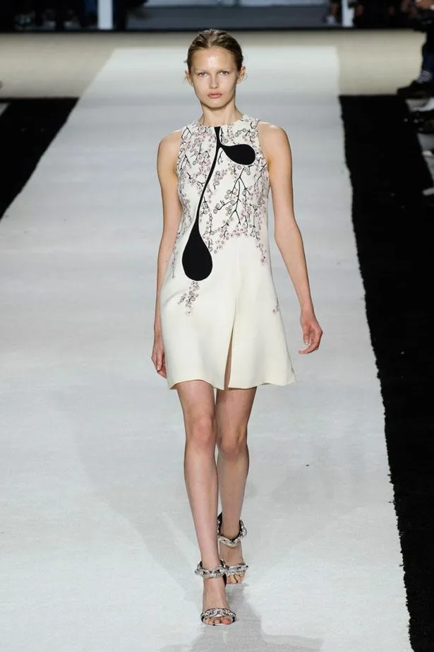 Model walking in Giambattista Valli Spring/Summer 2015 runway wearing a sleeveless cream dress with floral design.