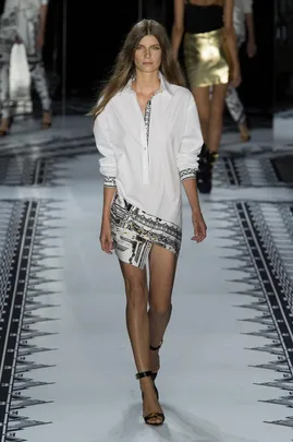 Model walking the runway in Versace Spring/Summer 2015 collection, wearing a white shirt and patterned skirt.