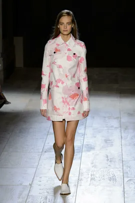 Model in pink floral coat and white shoes walking runway at Victoria Beckham SS15 show.