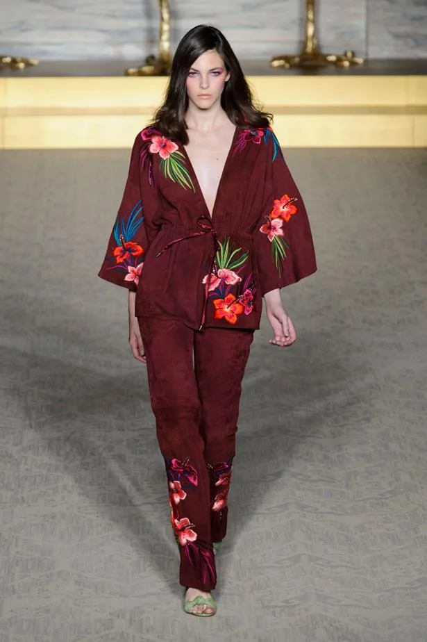 Model walks runway in burgundy floral-print outfit at Matthew Williamson's Spring/Summer 2015 show.