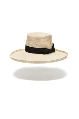 Straw hat with wide brim and black ribbon, floating over white background.