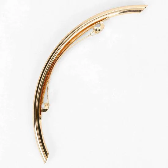 Curved gold tone safety pin resembling a scythe with small decorative elements.