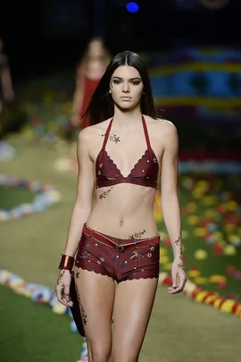 Model wearing a red bikini with star tattoos on the runway at Tommy Hilfiger AW15 show.