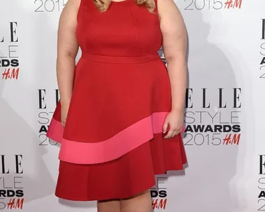 Rebel Wilson in a red and pink dress at the Elle Style Awards 2015, posing on the red carpet.