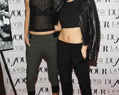 Kendall and Kylie Jenner standing together at a DuJour event on a red carpet.