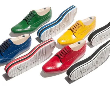 Prada's colorful Derby shoes with thick white soles in green, blue, yellow, and red, displayed with matching raised soles.