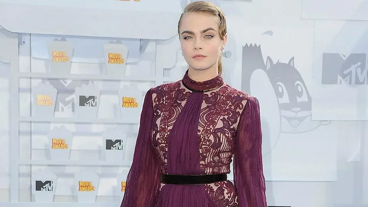 Cara Delevingne in a burgundy dress at the MTV Movie Awards.