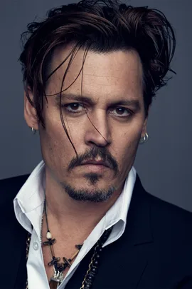 Johnny Depp in a Dior promotional photo with tousled hair, goatee, and white shirt under a black jacket, adorned with necklaces.