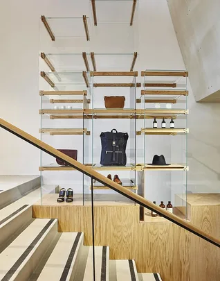 Wooden and glass shelves displaying fashion accessories and products at the APC Sydney store.