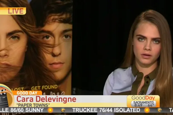 Cara Delevingne on Good Day Sacramento discussing "Paper Towns" with a movie poster in the background.