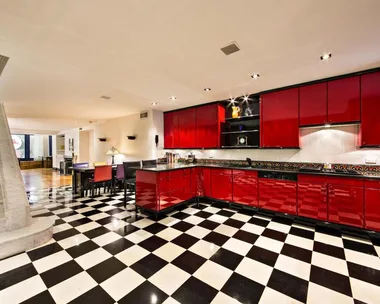 Red kitchen with checkered floor and sleek cabinets in Marilyn Monroe's Upper East Side apartment.