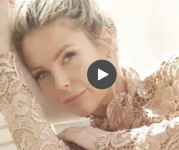 "Jennifer Hawkins poses in a lace top for Elle cover shoot, resting her head on her hand with a serene expression."