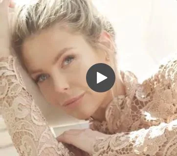 "Jennifer Hawkins poses in a lace top for Elle cover shoot, resting her head on her hand with a serene expression."