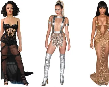 Three women in revealing outfits at an award show, wearing black sheer dress, silver futuristic attire with boots, and gold see-through gown.