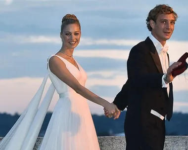 Beatrice Borromeo in an Armani wedding gown, holding hands with her partner outdoors during their wedding ceremony.