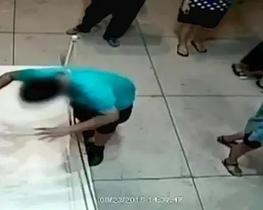 A boy accidentally punches a hole through a painting in an exhibition room as visitors look on.