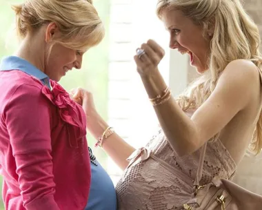 Two pregnant women excitedly compare baby bumps. Scene from the movie "What to Expect When You're Expecting."