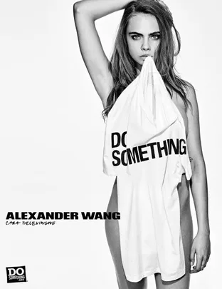 Black and white image of a woman holding a "Do Something" shirt, part of Alexander Wang's charity collaboration.