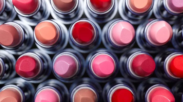 Aerial view of various lipsticks in different shades organized in rows.