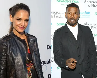 Katie Holmes in a black leather jacket and Jamie Foxx in a suit, standing in front of promotional backdrops.