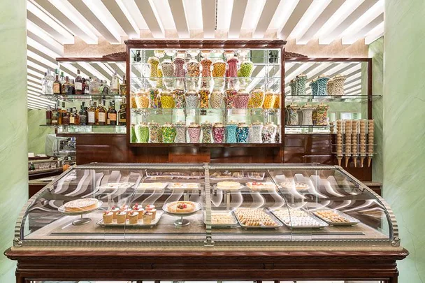 Display case with assorted pastries and desserts, and shelves filled with colorful glass jars of candies at Marchesi Pasticceria.