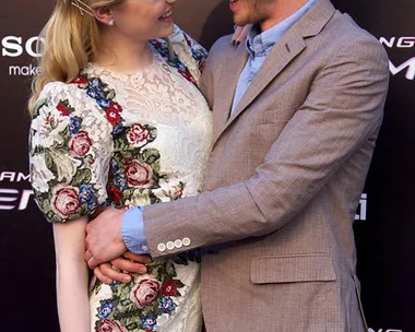 Actors from "The Amazing Spider-Man" smile at each other on the red carpet, embraced closely, wearing formal attire.