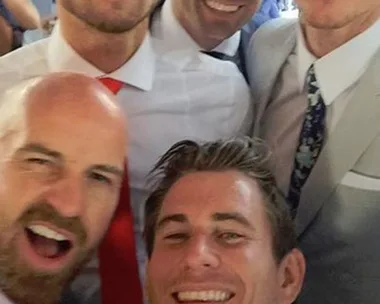 Group of five men in suits taking a selfie, smiling at the Melbourne Cup.