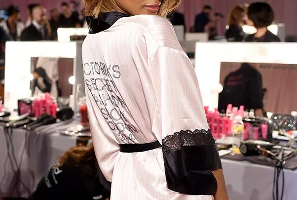 Jourdan Dunn wearing a Victoria's Secret robe backstage at a fashion show, looking over her shoulder.