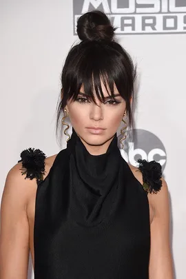 "Kendall Jenner with new fringe hairstyle, wearing black outfit with high neck, at the Music Awards red carpet event."