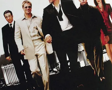 "Poster of Ocean's Eleven with George Clooney, Brad Pitt, Matt Damon in suits, Las Vegas sign in background."