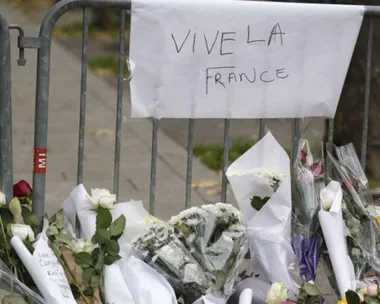 Memorial with flowers and a sign reading "Vive la France" in tribute to the Paris attack victims.