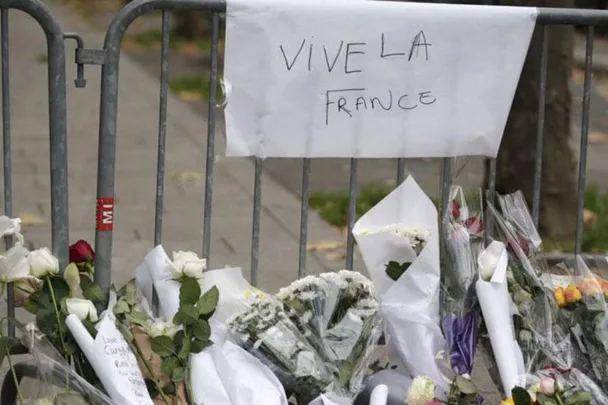 Memorial with flowers and a sign reading "Vive la France" in tribute to the Paris attack victims.