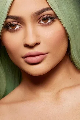 Close-up of a woman with green hair, full lips, and brown eyes, showcasing the Kylie Lip Kit.