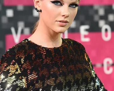 Taylor Swift at the MTV Video Music Awards in a sequined crop top, looking towards the camera.