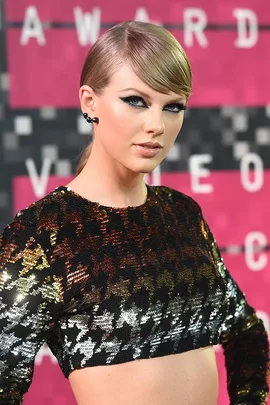 Taylor Swift at the MTV Video Music Awards in a sequined crop top, looking towards the camera.