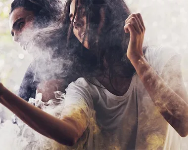 Two models in casual T-shirts surrounded by smoke in an ethereal, dreamy setting.