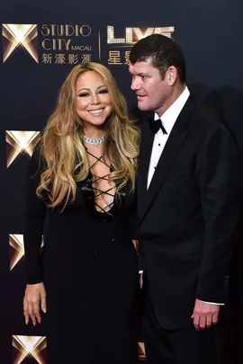 Mariah Carey and James Packer smiling at a formal event, Carey in a black dress, Packer in a black suit.