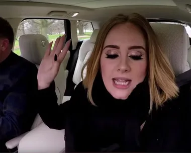 Adele rapping in the passenger seat while James Corden drives during Carpool Karaoke.