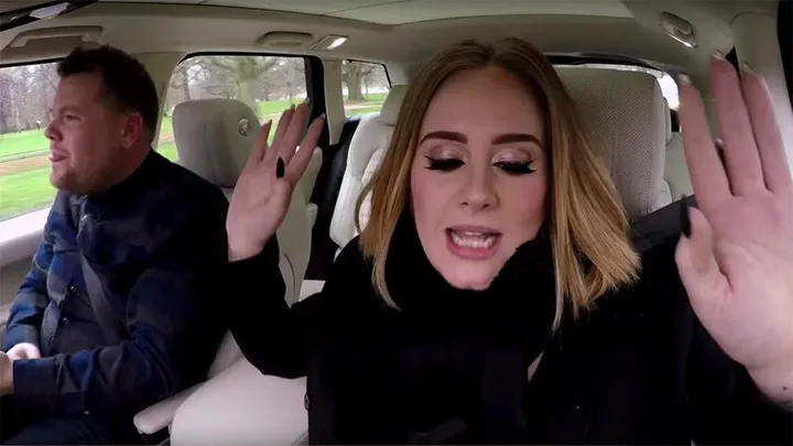 Adele rapping in the passenger seat while James Corden drives during Carpool Karaoke.