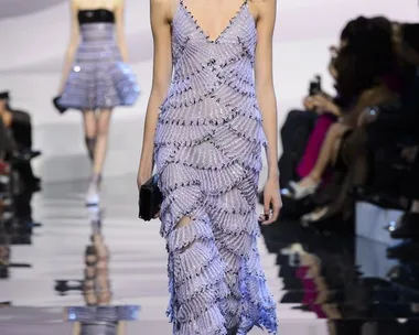 Model walking on runway in a lavender, fringed Giorgio Armani Prive dress during the Haute Couture SS16 show.