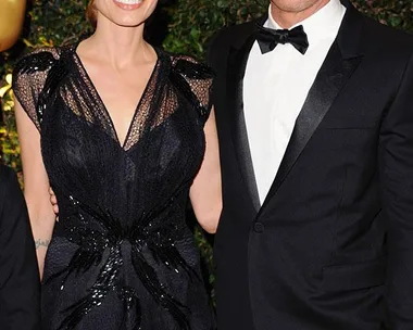 A woman and a man in formal attire smiling at an event.