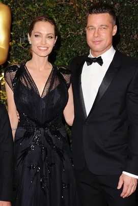 A woman and a man in formal attire smiling at an event.