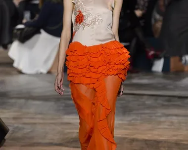 Model in an orange ruffled skirt and embellished top walks runway at Christian Dior Haute Couture SS16 show.