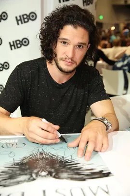 Actor signing a Game of Thrones poster at an HBO event.