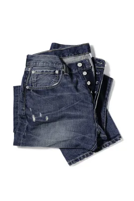 A pair of blue jeans with a small front pocket, commonly known as a coin pocket, on a white background.