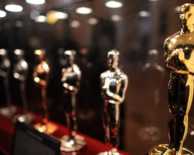 Rows of Oscar statuettes displayed in a glass case for the 2016 nominations.