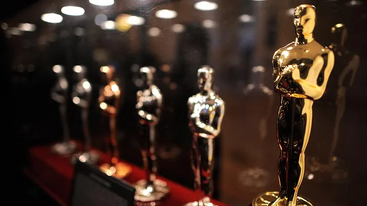 Rows of Oscar statuettes displayed in a glass case for the 2016 nominations.