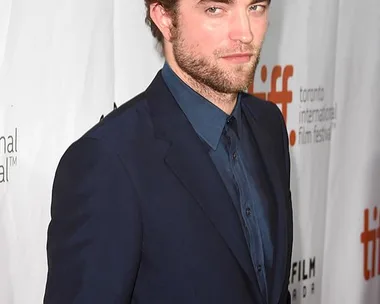 A man in a navy blue suit at the Toronto International Film Festival, standing in front of a backdrop with TIFF and Bell logos.