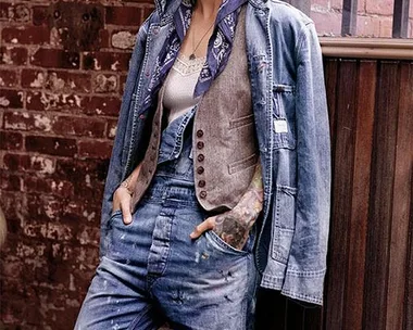 A model in a denim outfit and hat poses against a rustic brick wall in a Ralph Lauren campaign.